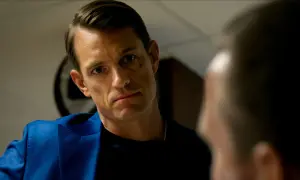 Joel Kinnaman i blå kavaj, intensiv blick mot någon i närbild. Ser ut som en scen från en ny serie.