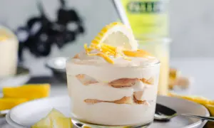 Un délicieux tiramisu limoncello, superposé de biscuits et de crème, garni d'une tranche de citron et de zestes.