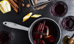 Aromatyczne wino z herbaty, z cynamonem, goździkami i skórką pomarańczy, gotowe do podania w szklankach.