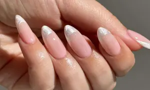 Delikatne, różowe paznokcie w stylu princess nails french z błyszczącym, srebrnym wykończeniem na końcówkach.