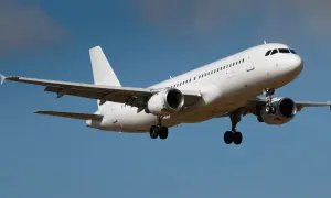 Biały samolot pasażerski z wysuniętym podwoziem, gotowy do lądowania. Idealny środek transportu, by przywieźć z Turcji pyszne baklawy i aromatyczne przyprawy.