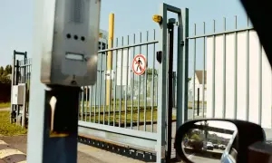 Brama przesuwna z interkomem i znakiem zakazu ruchu pieszego. Wymiary bramy nie są widoczne, ale widać jej konstrukcję.