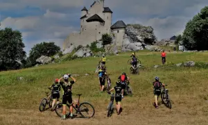 Grupa rowerzystów zdobywa zamek na Jurze Krakowsko-Częstochowskiej.
