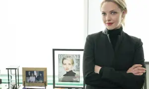 Amanda Seyfried som Elizabeth Holmes i "The Dropout", med armarna i kors och en tidning med hennes ansikte på.