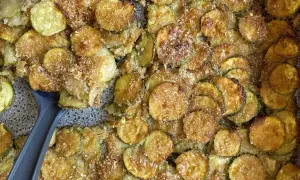 Fette di zucchine al forno, dorate e croccanti, con pangrattato e parmigiano. Un contorno saporito e facile da preparare.