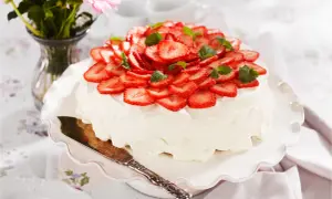 En vacker jordgubbstårta med vispgrädde och färska jordgubbar, perfekt för ett sommarfika. Ett enkelt jordgubbstårta recept att prova!