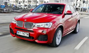 Czerwone BMW X4 w ruchu miejskim. Wady tego modelu to m.in. ograniczona widoczność z tyłu i wysoka cena.
