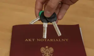 Klucze do nowego domu leżą na akcie notarialnym, symbolizującym własność.