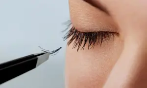 Pęseta precyzyjnie aplikuje kępkę rzęs, by uzyskać efekt kim.