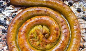 Złocista kiszka ziemniaczana zwinięta w spiralę na folii aluminiowej.