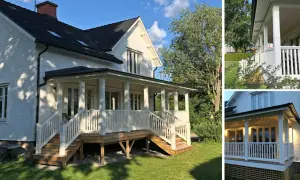 Vitt hus med en charmig veranda entré. Trappor leder upp till en vitmålad veranda med räcke och pelare.