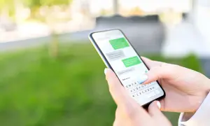 Dłoń trzyma smartfon z widoczną klawiaturą. Dowiedz się, jak przywrócić ustawienia klawiatury w telefonie, gdy coś pójdzie nie tak.