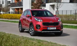 Czerwony Kia Sportage 4 na drodze, gotowy do wymiany żarówki.