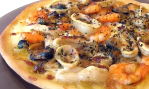 Une délicieuse pizza fruit de mer, garnie de crevettes, moules et calamars, saupoudrée d'herbes.