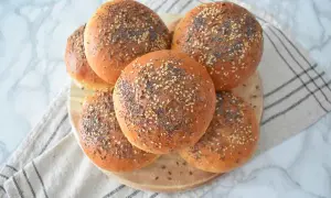 Pięć złotych bułek posypanych sezamem, makiem i siemieniem lnianym. Idealne do burgerów, jak w tym przepisie na bułki.