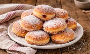 Ein Haufen frisch gebackener Berliner, bestäubt mit Puderzucker. Dieses berliner rezept ist ein Genuss für jeden Kaffeetisch.