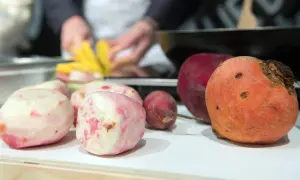 Bunte Bete, frisch geschält und bereit für die Zubereitung. Eine rote und eine orangefarbene Bete liegen daneben.