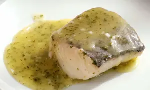 Filete de pescado blanco bañado en una sabrosa salsa verde, con hierbas picadas y un toque de ajo.