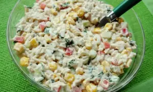 Pyszna sałatka z tuńczykiem, ryżem, kukurydzą, papryką i ogórkiem, polana kremowym sosem. Idealna na szybki lunch.