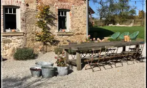 Rusty metal chairs await guests at a rustic table outside a stone building. Ideal agroturystyka Dolny Śląsk.