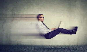 Uomo d'affari con laptop, in movimento rapido, sembra che stia facendo fast tracking verso il successo.