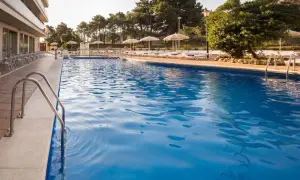 Basen w Lloret de Mar we wrześniu. Idealna pogoda na relaks przy basenie, z leżakami i parasolami.