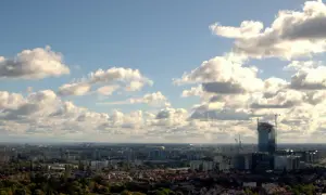 Widok na Gdańsk z wieży widokowej. W oddali widać nowoczesny wieżowiec w budowie, a pod nim rozciąga się panorama miasta.