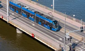 Blauer Straßenbahnzug fährt über eine Brücke, auf dem Weg von Görlitz nach Breslau.