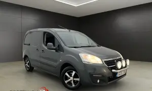 Grå Peugeot Partner skåpbil med extraljus. Tänk på peugeot kamremsbyte intervall för att hålla den i toppskick.