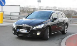 Czarny Peugeot 508 GT na drodze, przygotowany do wymiany żarówki z przodu.
