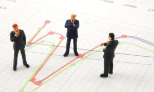 Trzej biznesmeni analizują przykładowy portfel inwestycyjny na wykresie.