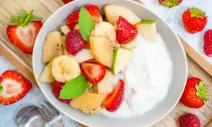 Frischer Obstsalat mit Joghurt, Erdbeeren, Bananen, Äpfeln und Himbeeren. Ein einfaches obstsalat rezept für jeden Tag.