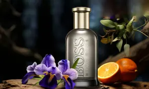 Elegancki flakon Hugo Boss Bottled 100ml otoczony fioletowymi irysami i soczystymi pomarańczami, sugeruje świeżość i wyrafinowanie.