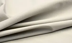 Beżowa tkanina z drobnym wzorem, która sprawia, że zastanawiasz się, czy elastan to dobry materiał.