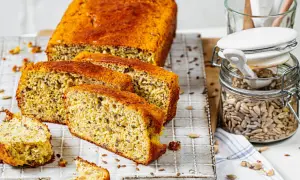 Ein saftiges low carb brot rezept mit Sonnenblumenkernen und Leinsamen, frisch aufgeschnitten auf einem Gitter.