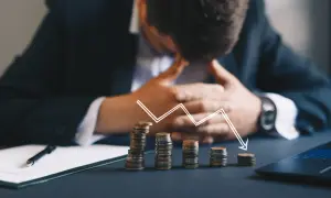 Zastanawiasz się, kto z polskich celebrytów ogłosił upadłość konsumencką w tym miesiącu? Obrazek pokazuje stosy monet i wykres spadkowy, symbolizujące problemy finansowe.