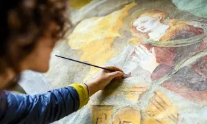 Restauration d'une vieille peinture qui sent mauvais, une main délicate redonne vie à une fresque ancienne.