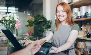 Uśmiechnięta sprzedawczyni w kwiaciarni obsługuje płatność kartą. Paragon z nipem do jakiej kwoty?