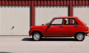 Röd Renault 5 GL står parkerad framför en röd och vit garagebyggnad. Denna klassiska le car är redo för en tur.