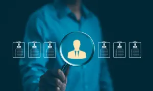 Szukamy idealnego kandydata. Lupa powiększa sylwetkę pracownika, pokazując, jak działa agencja pracy, dopasowując talenty do firm.