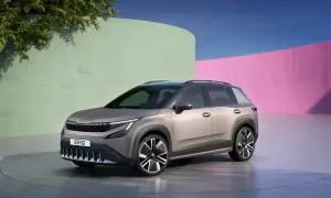 Nowy, elektryczny SUV Škoda Enyaq, z nowoczesnym designem i napisem Enyaq na grillu, prezentuje się na tle kolorowych ścian.
