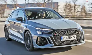 Szary Audi RS3 na drodze. Kierowca w okularach. Sprawdź audi rs3 cena i osiągi.