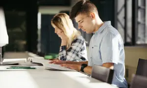 Estudiantes concentrados estudiando para entender como funcionan las oposiciones de maestro.