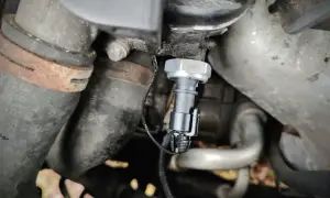 Czujnik ciśnienia oleju 1.9 TDI znajduje się w pobliżu metalowych rur i przewodów silnika.