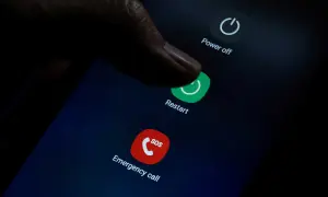 Palec naciska przycisk "Restart" na ekranie telefonu, co może pomóc, gdy zastanawiasz się, jak przywrócić poprzednie ustawienia telefonu.