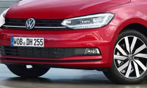 Czerwony Volkswagen Touran z błyszczącym logo i nowoczesnymi światłami.