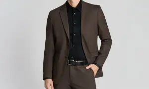 Mann im braunen Anzug mit schwarzem Hemd. So lässt sich ein schwarzes Hemd kombinieren für einen eleganten Look.