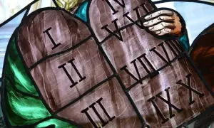 Fragment witrażu przedstawiający kamienne tablice z rzymskimi cyframi od I do X.
