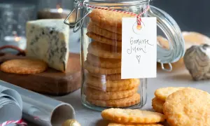 En burk med staplade parmesan kex, en bit blåmögelost och juldekorationer. Perfekt för julens fika!