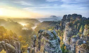 Morgendlicher Nebel über Felsformationen und Wäldern in der Sächsischen Schweiz. Ein perfekter Ort für einen Urlaub in Sachsen.